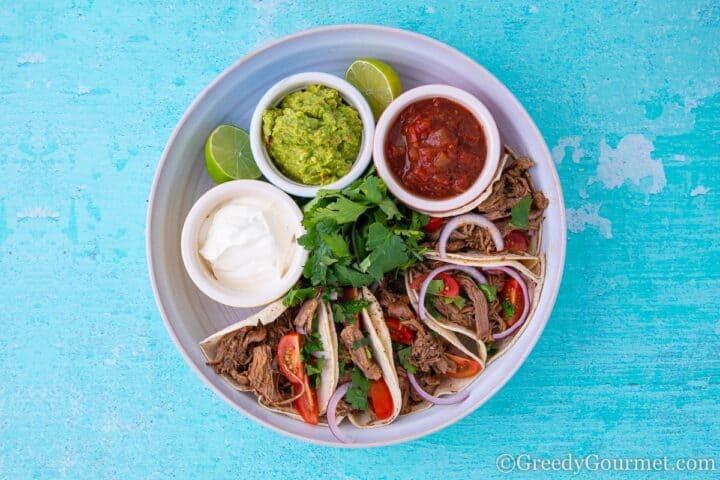 Lamb tacos with sour cream, salsa and guacamole 