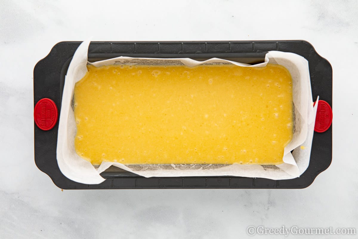 cake batter in a tin lined with baking paper.