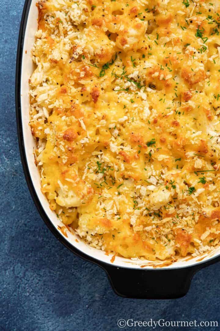Cauliflower cheese in dish with a blue backgroun