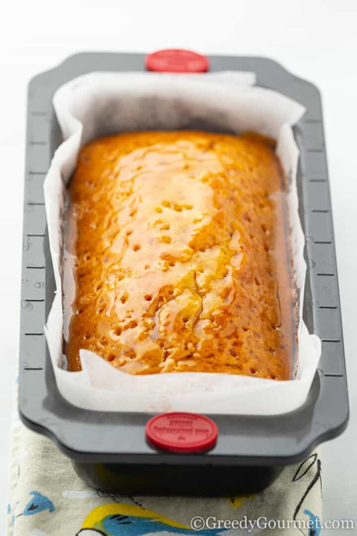 golden loaf cake drizzled with syrup.
