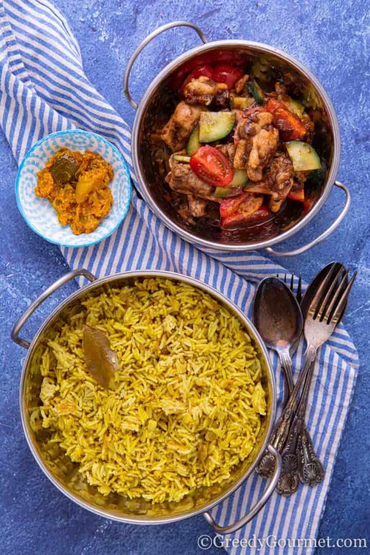 Pilau Rice in dish with curry alongside it