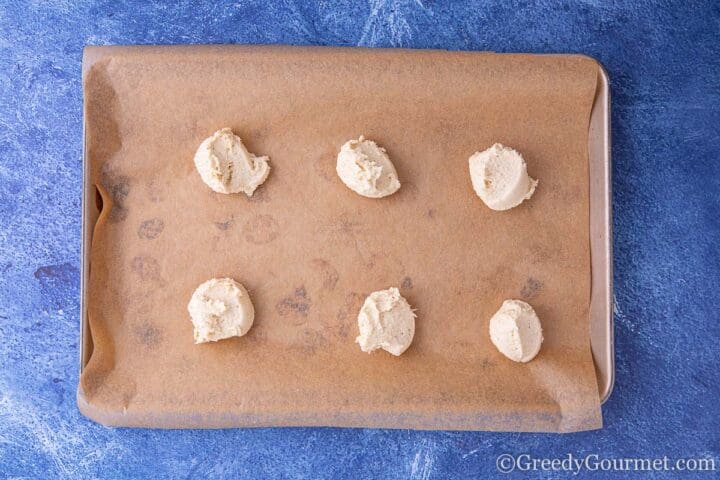 raw cookie piles on a sheet tray,