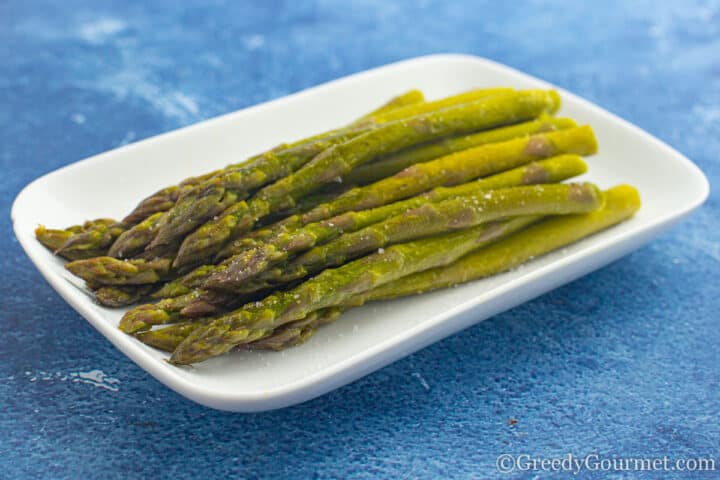 asparagus on a white plate with salt