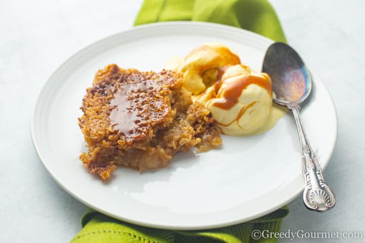 Slice of Salted Caramel Apple Crumble served with ice cream on plate