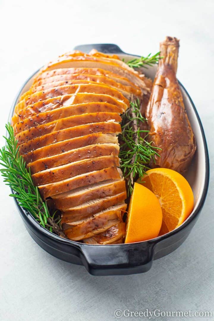 cooked turkey in a pot with orange slices and thyme