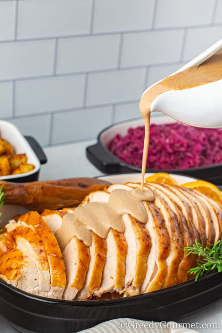 Turkey Giblet Broth being poured over whole roast turkey