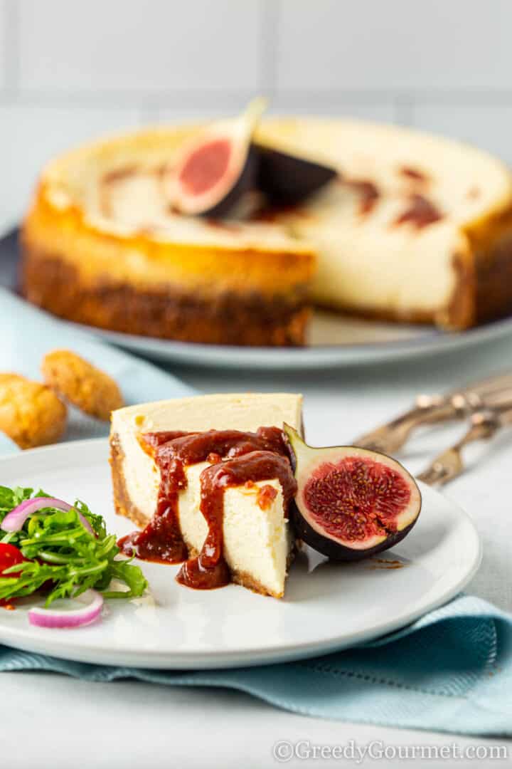 Slice of Parmesan Cheesecake with Fig and Orange Sauce drizzled on top