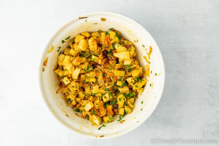 Bowl full of stuffing mixture including apricots