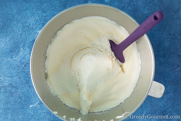 Folding flour into the cream to make a yule log recipe
