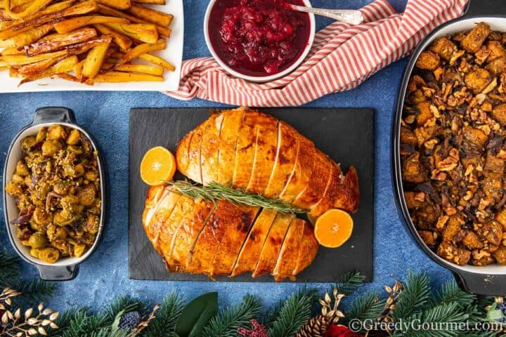 turkey, apple cranberry sauce, potatoes and vegetables laid out on a table