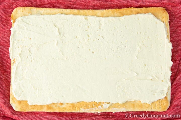 Buttercream spread onto a baked yellow sheet cake