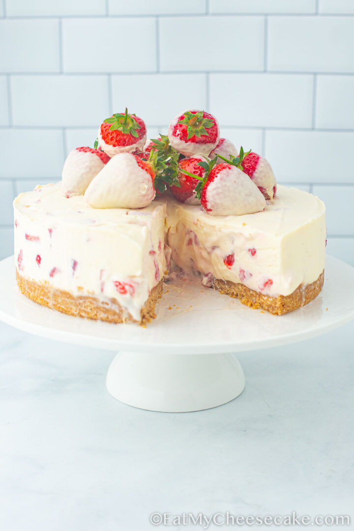 strawberry and white chocolate cheesecake with a slice taken out.