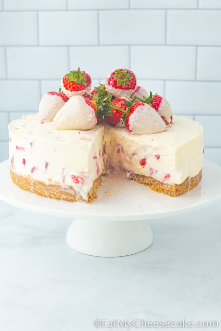 strawberry and white chocolate cheesecake with a slice taken out.