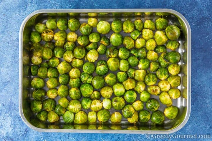 raw brussels sprouts leaves on a baking tray.