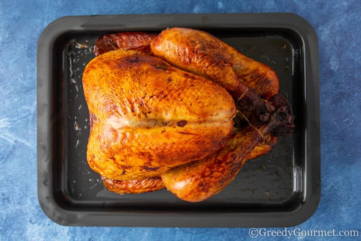 whole roasted turkey in a black pan.