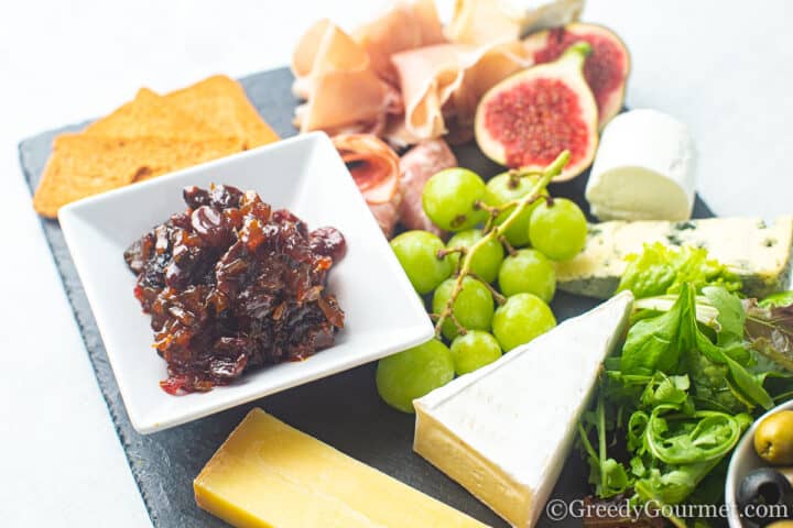 plate with chutney, cheese, grapes and crackers