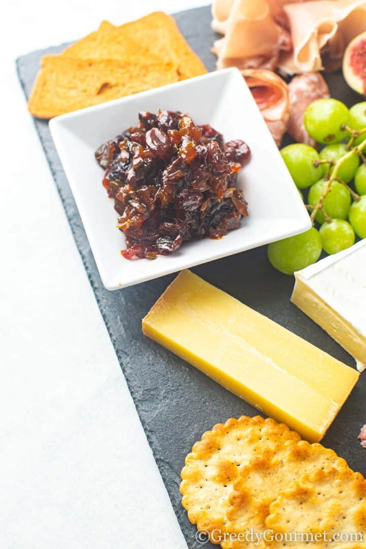 plate with chutney, cheese, grapes and crackers