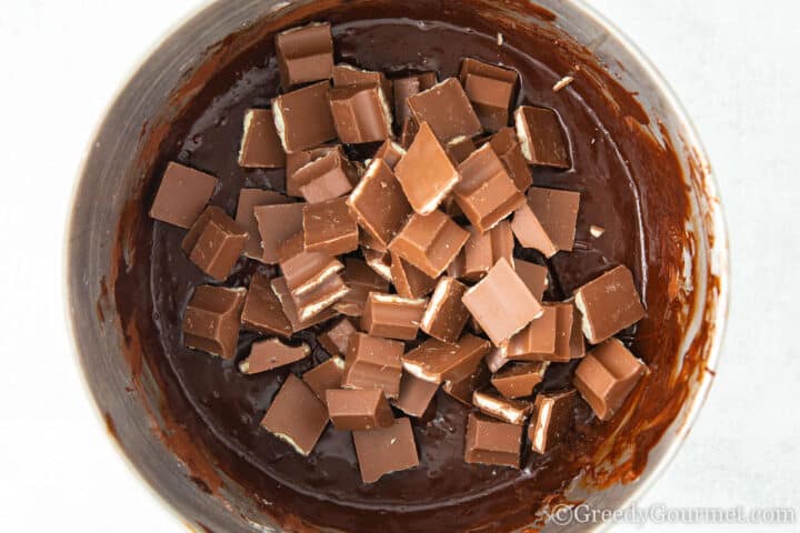Adding kinder chocolate to chocolate batter.
