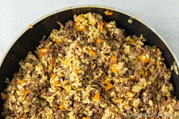 mixing beef, rice and vegetables.