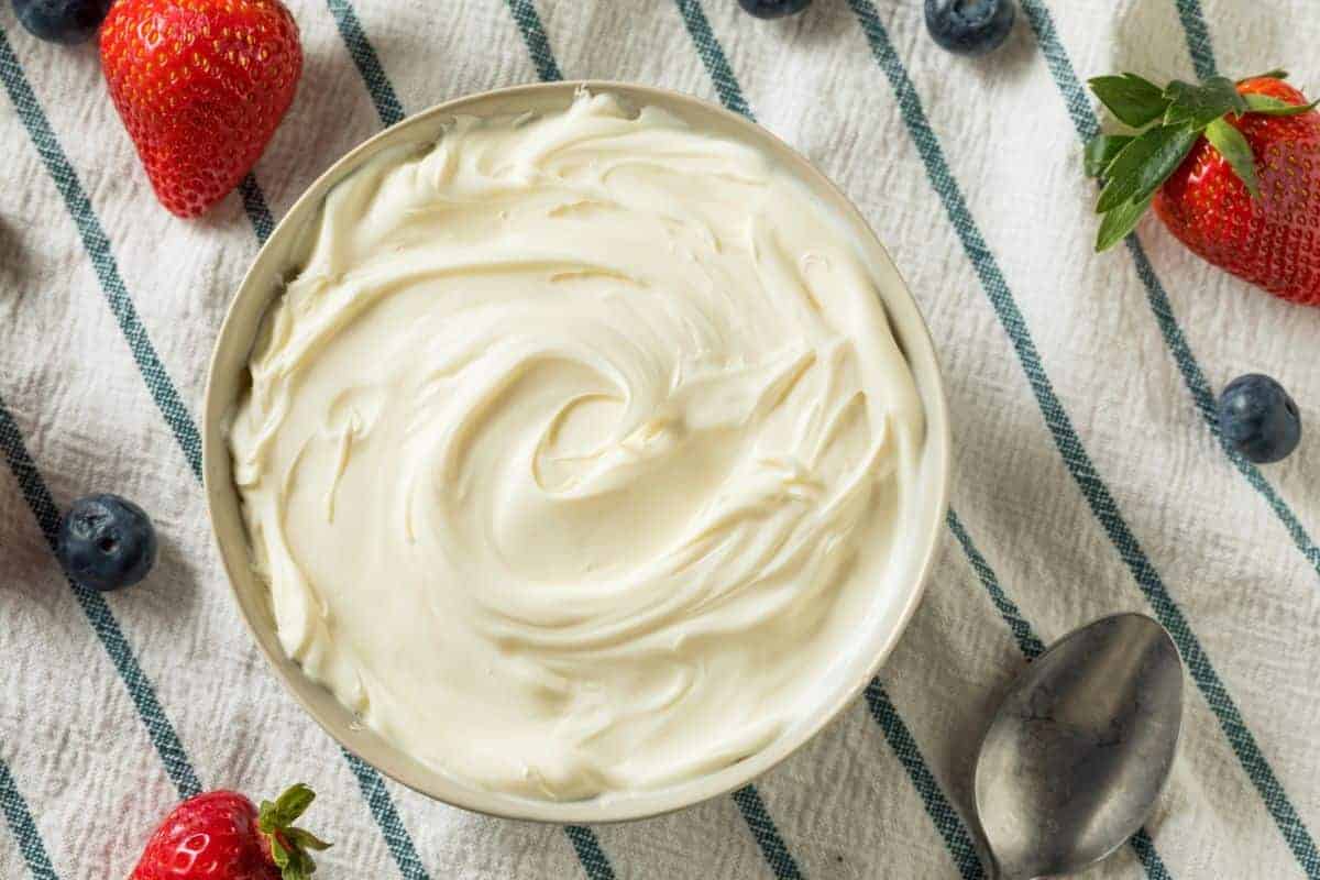 Mascarpone cheese with strawberries on a striped cloth.