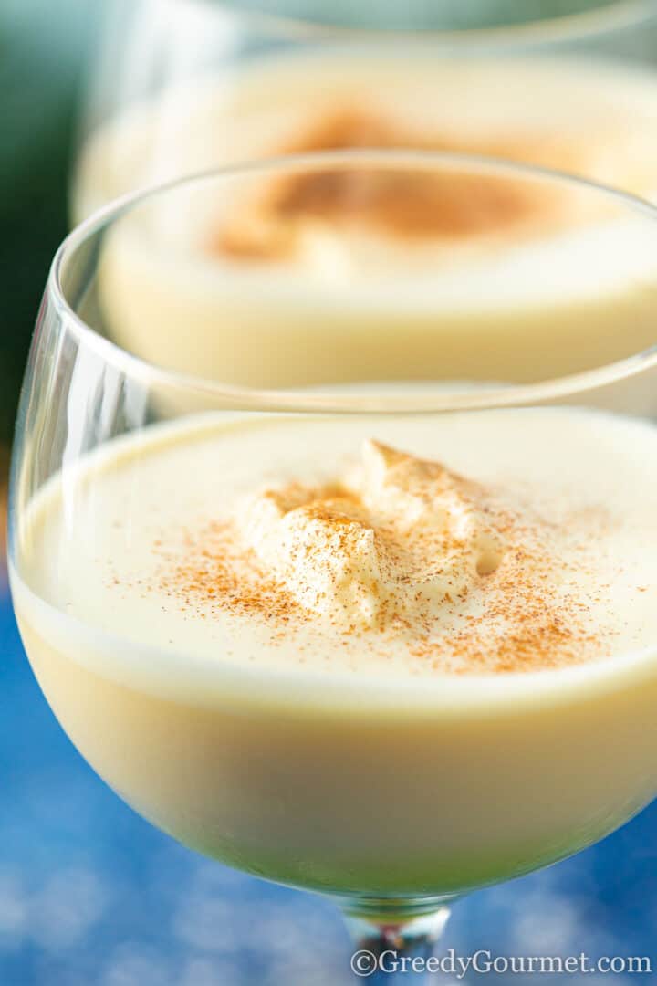 a glass of frothy rumchata eggnog