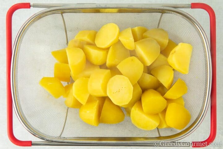 Boiled potatoes in a sieve.