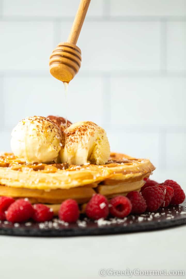 eggnog waffles topped with ice cream and drizzled with honey.