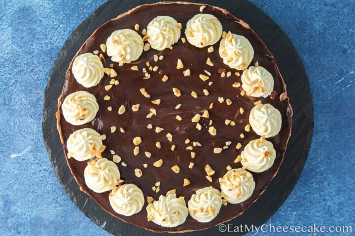 cream and nutty toppings on a chocolate cheesecake.