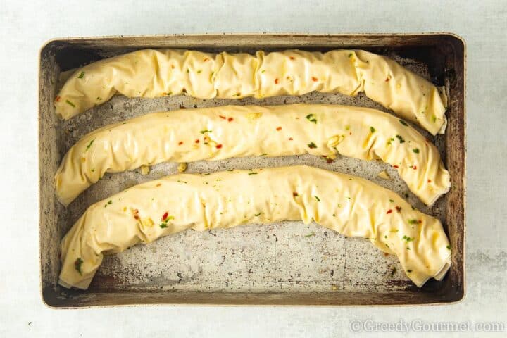 glazed rolled pastries in a pan.