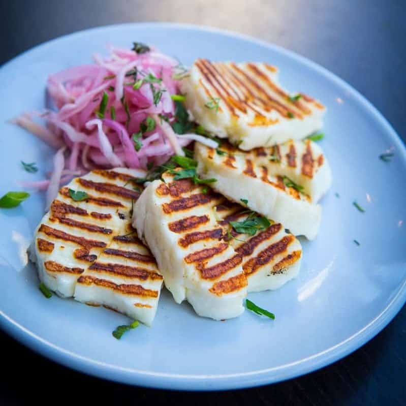 Halloumi Grilled with salad on a blue plate.