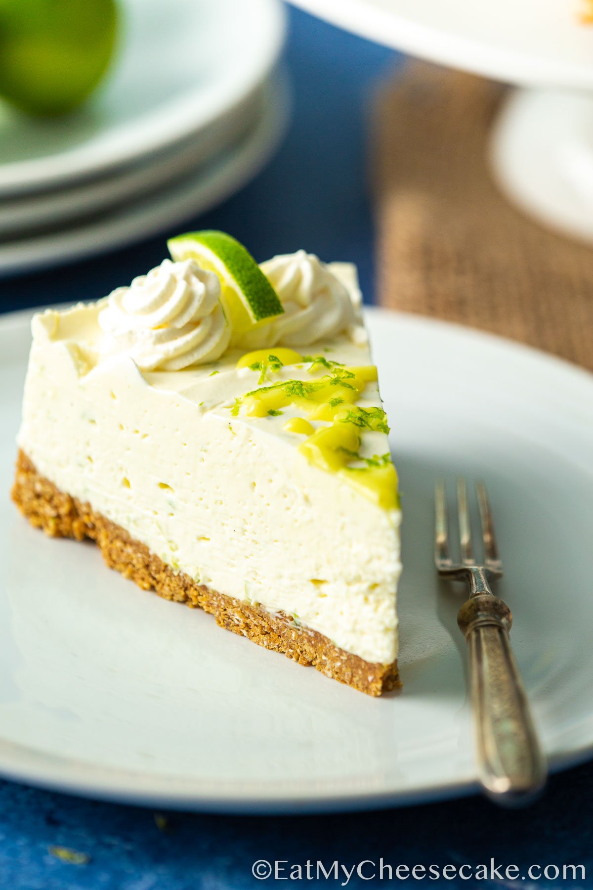 Slice of no bake lime cheesecake with lime curd drizzled on top.