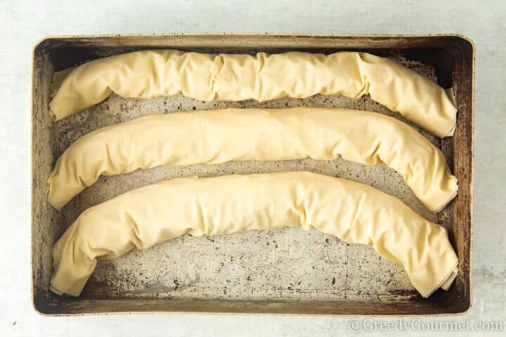 rolled chicken pastries in a pan.