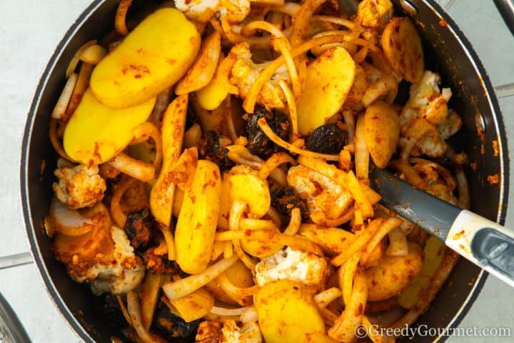 Adding spices to vegetables.