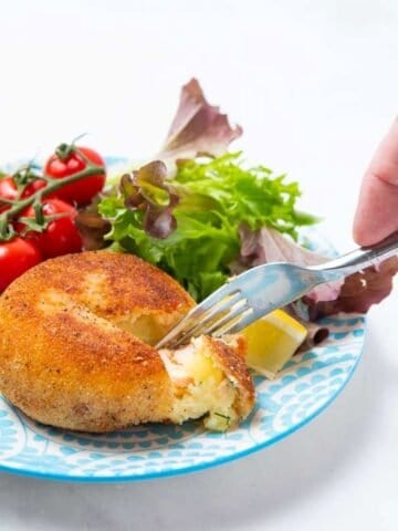 Eating salmon fishcake with a fork.