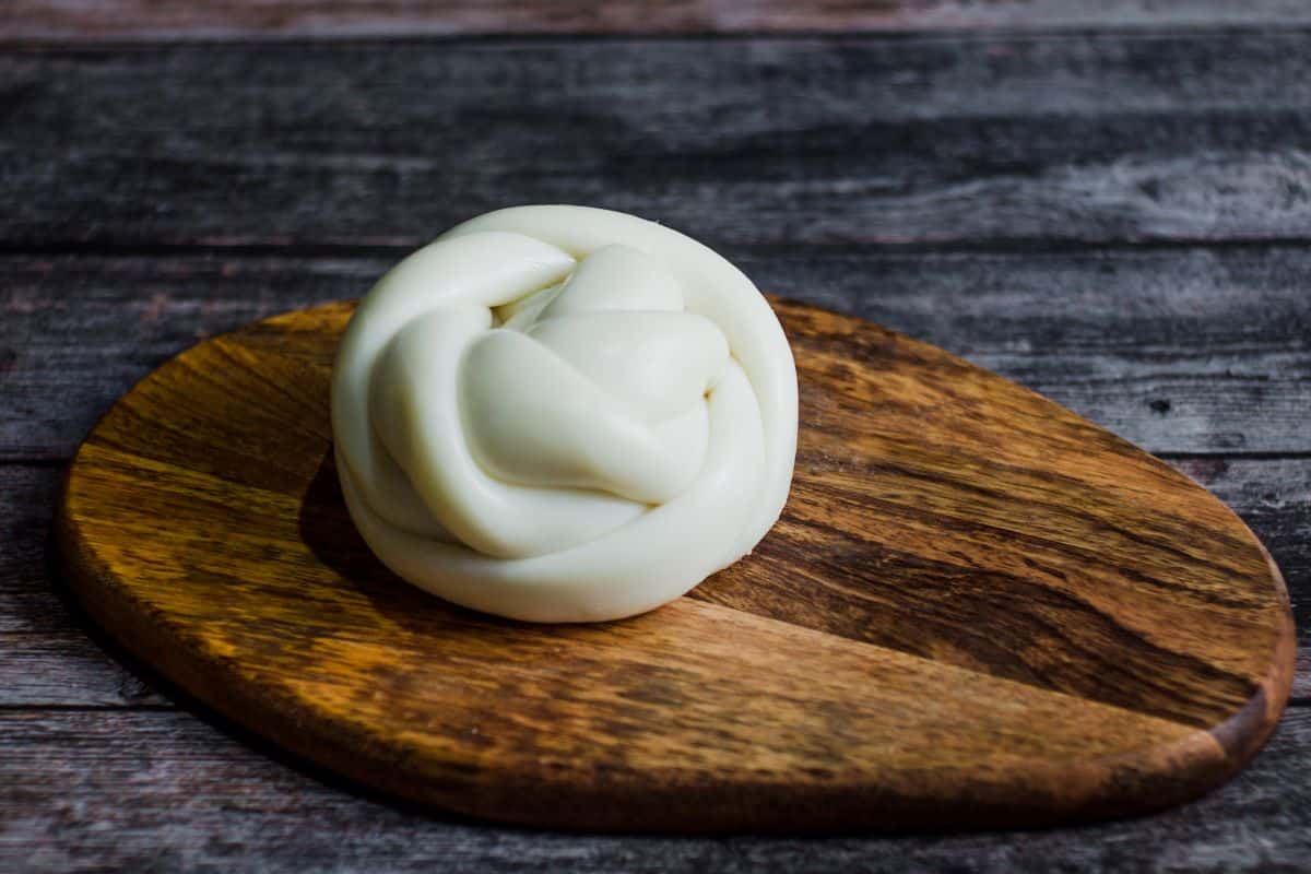 Oaxaca cheese on a wooden board.