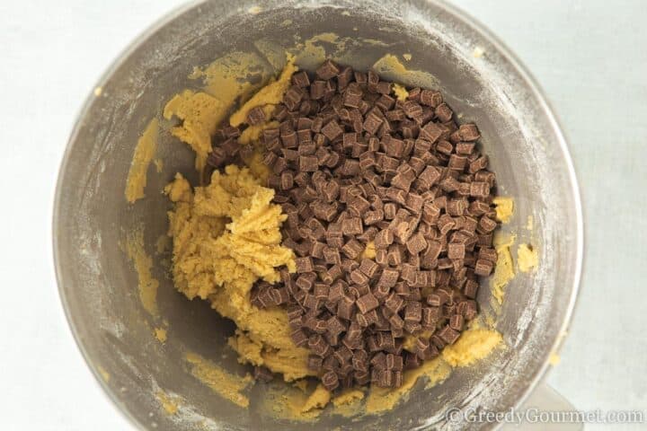 adding chocolate chips to cookie dough.