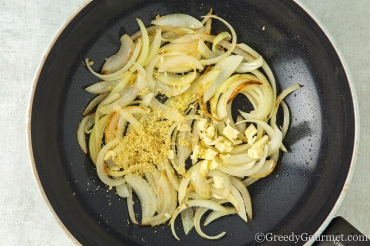adding garlic and ginger to the pan.