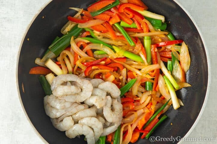 adding the prawns to vegetables.