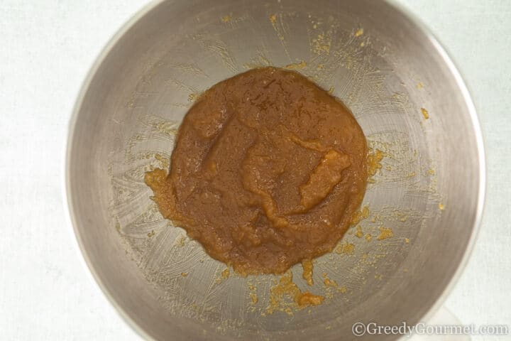 melted butter mixed with sugar in silver mixing bowl.