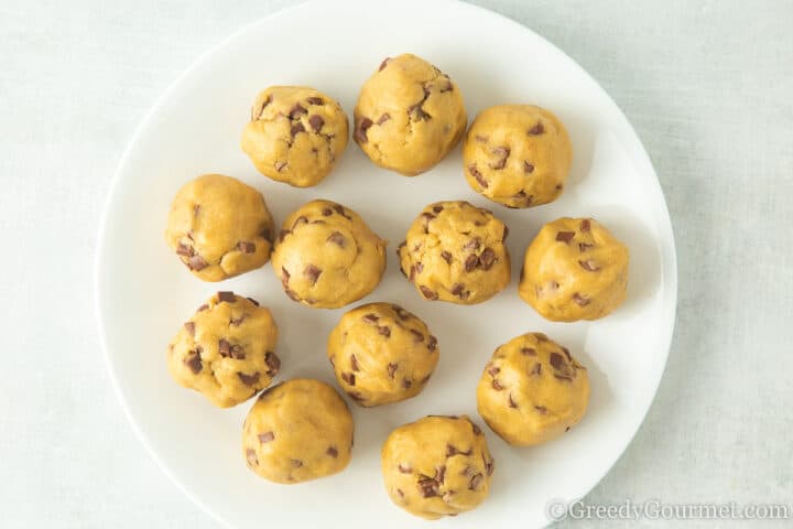 cookie dough balls on a white plate.
