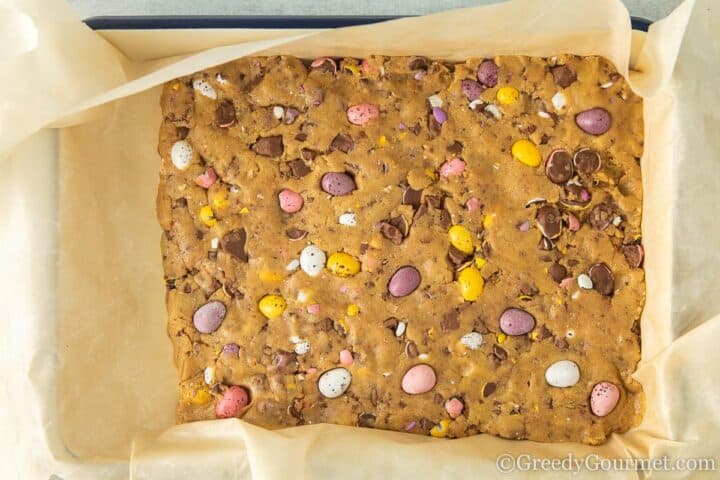 raw cookie dough in tin lined with baking paper.