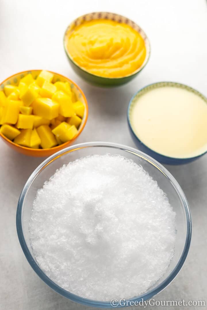 Bowls of ice,, mango, condensed milk and mango puree.