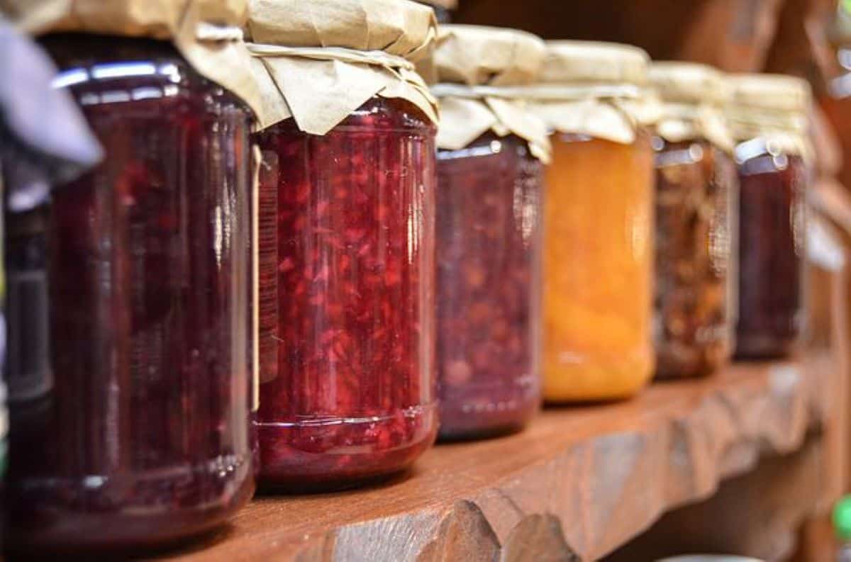 Jars of preserved fruit on a shelf.