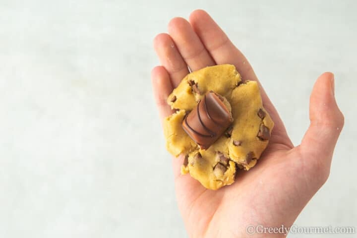 rolling cookie balls with a kinder bueno chocolate piece filliing.