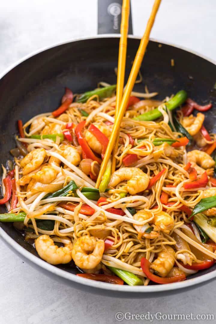 King prawn chow mein in pot with chopsticks.
