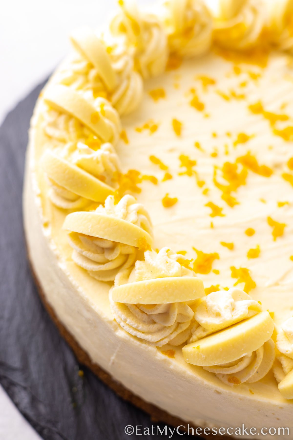 white chocolate orange cheesecake decorated with orange peel.