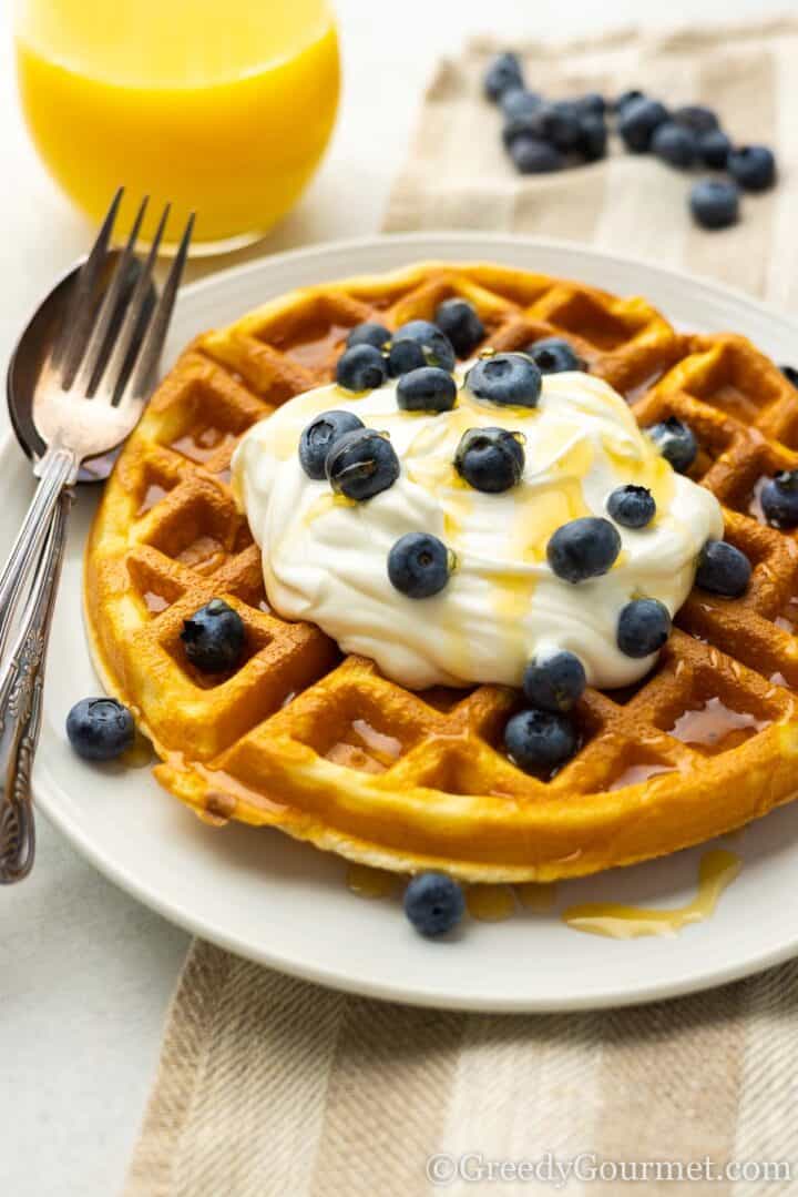 Mochi waffle served with honey and blueberries.