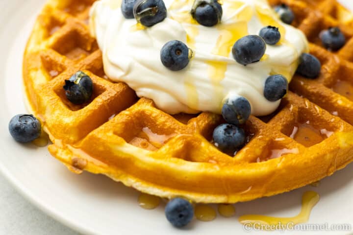 Mochi waffle served with honey and blueberries.