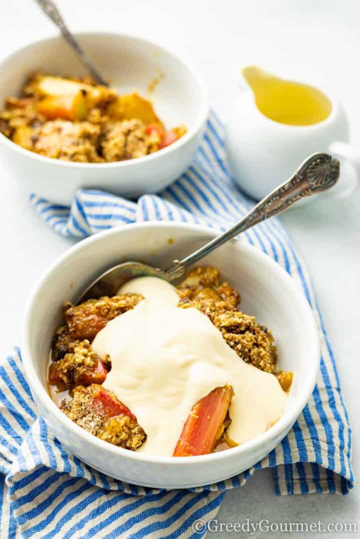 rhubarb and pear crumble with custard and a spoon.