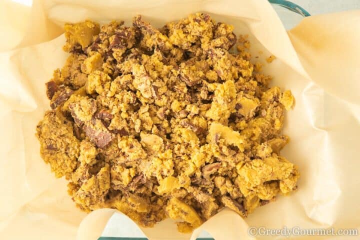 put raw cookie dough into lined baking tin.